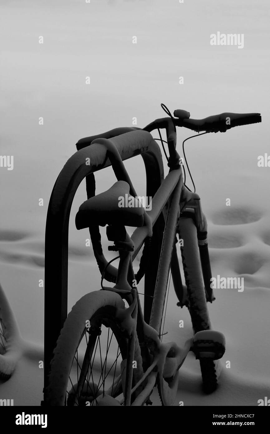 Fahrrad während eines Schneesturms am Stand geparkt. Stockfoto