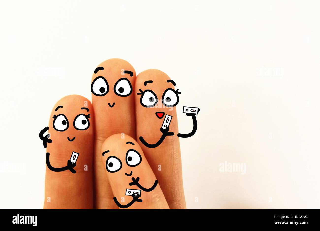 Vier Finger sind als Familie geschmückt. Sie verwenden zu Hause Coronavirus-Schnelltestkits. Sie sind alle negativ getestet. Stockfoto