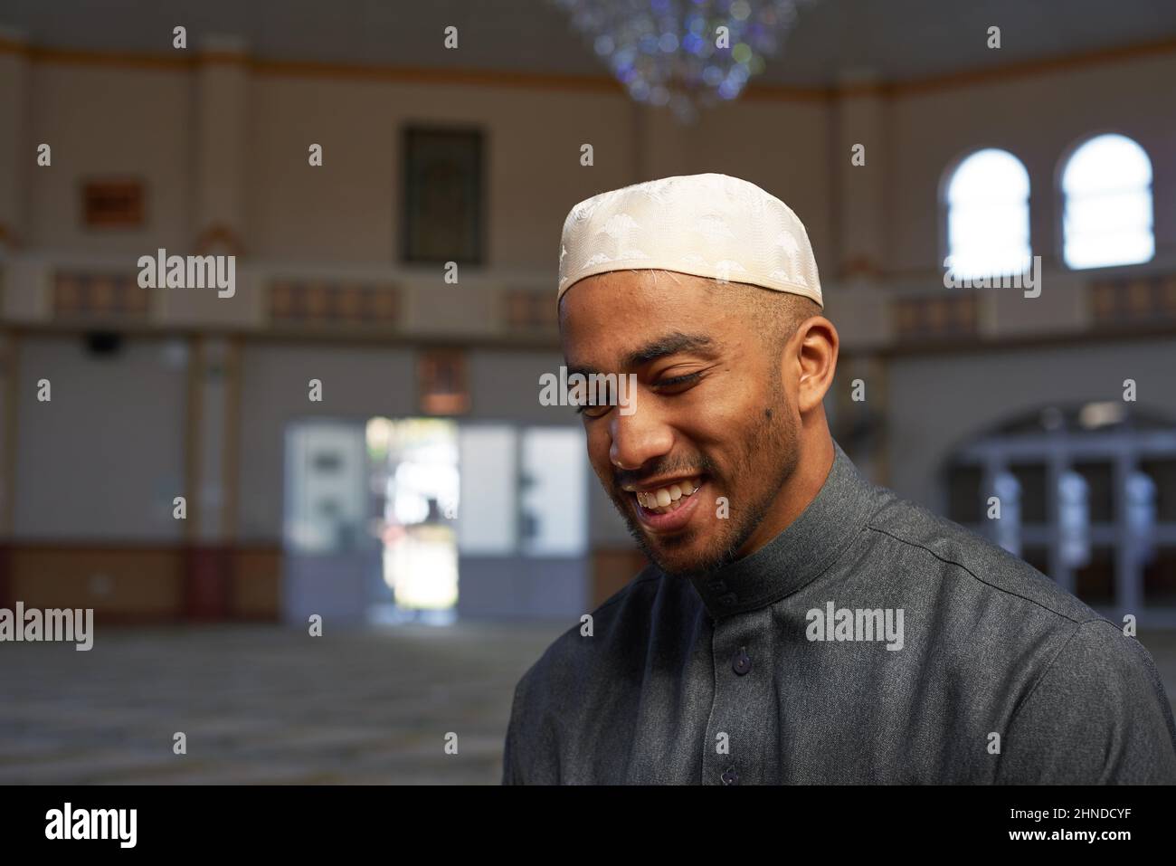 Ein junger muslimischer Mann lächelt in einer Moschee Stockfoto