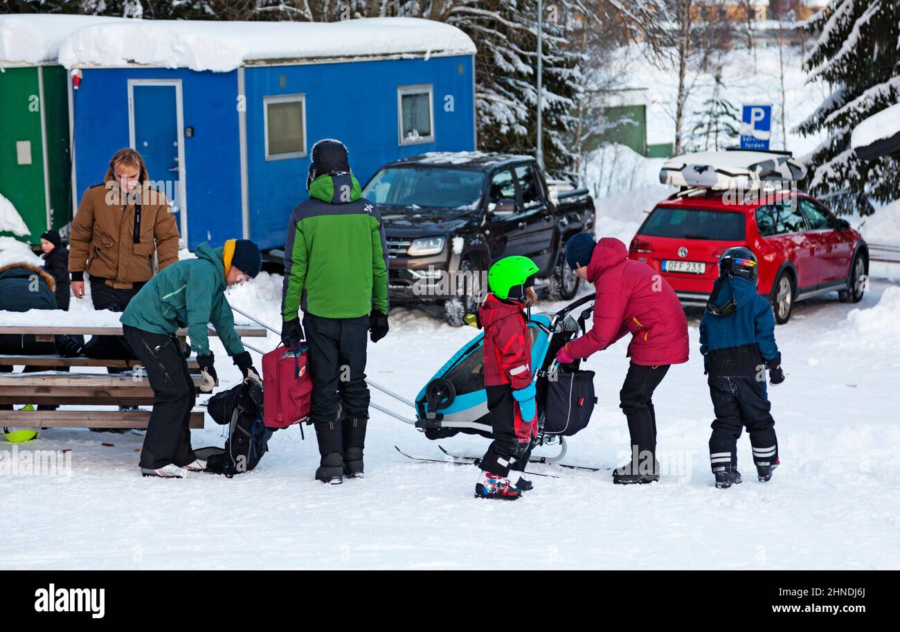 Umea, Norrland Schweden - 6. Februar 2021: Eine Familie im unteren Teil der Skipiste Stockfoto