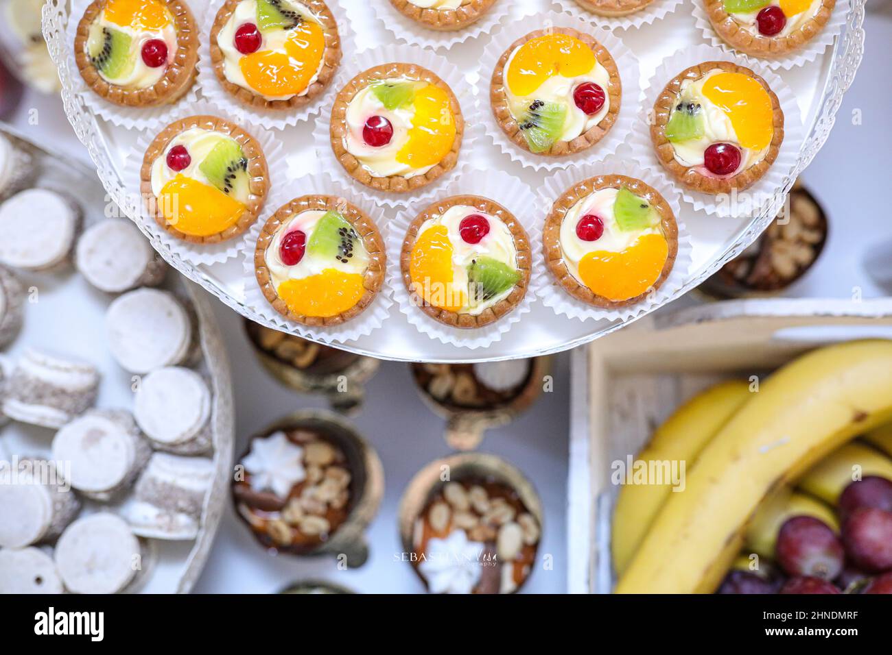 Obst Cupcakes Dekoration auf einem Teller mit Kuchen und Obst im Hintergrund Stockfoto