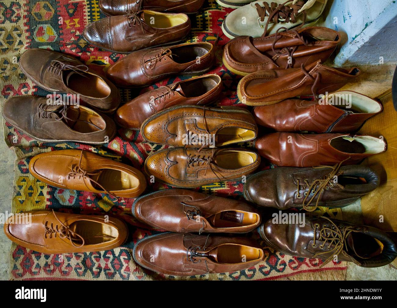 Alte gebrauchte Herrenschuhe und -Stiefel, die auf einem alten Teppich auf dem Brooklyn Flea Market ausgelegt wurden Stockfoto