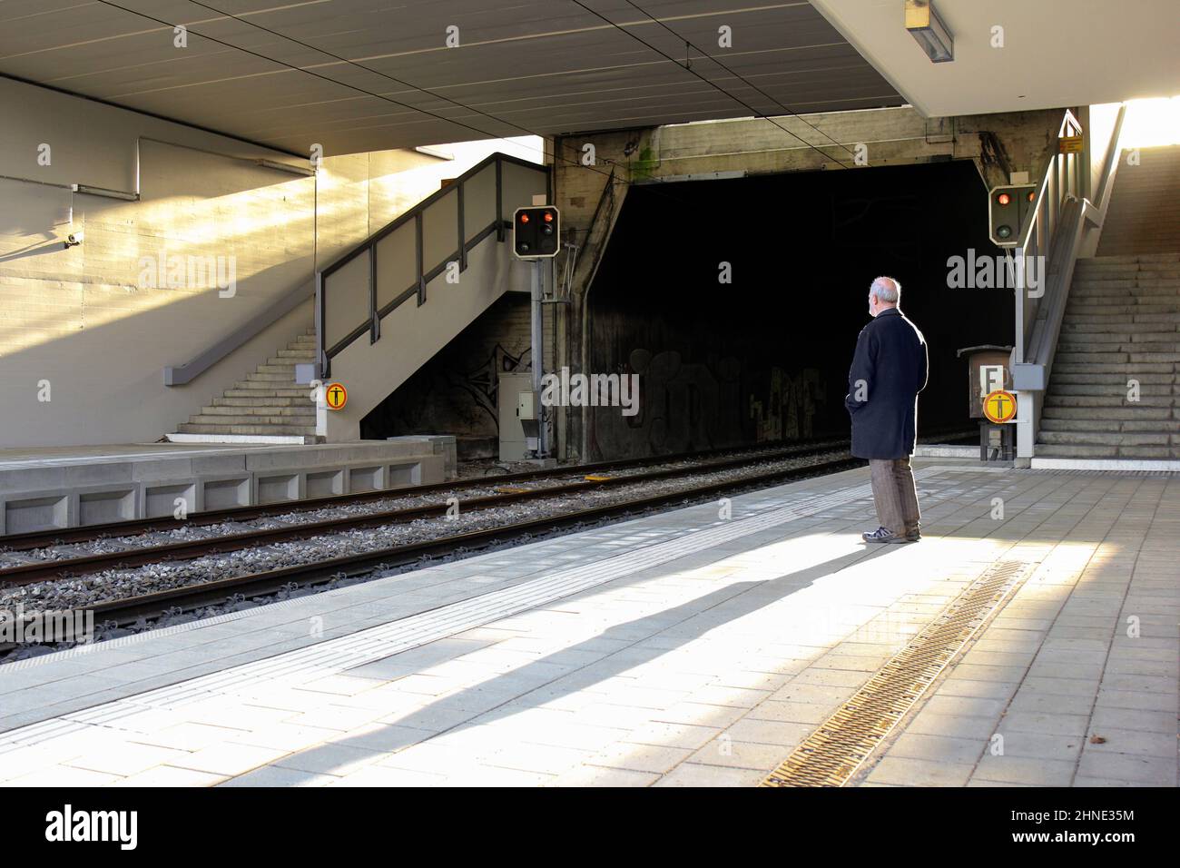 Einsamer Senior wartet auf einen verlassenen Bahnhof Stockfoto