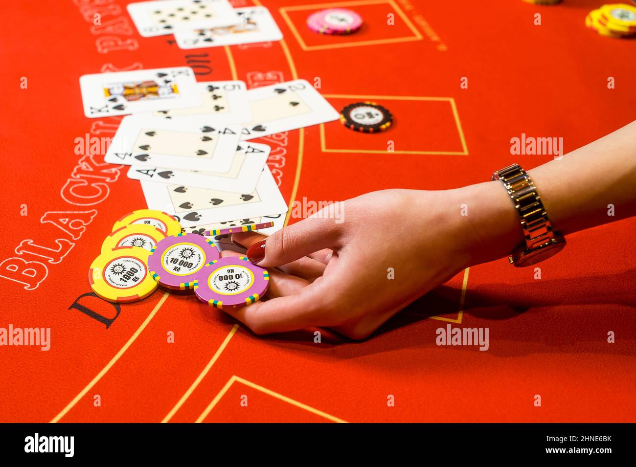 Hand hält Chips am Casino-Tisch Stockfoto