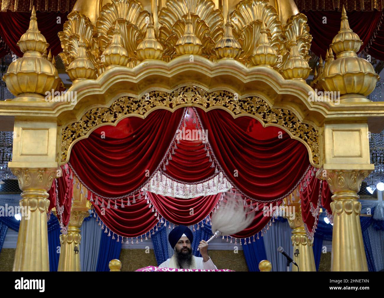 Eine Nahaufnahme eines Sikh Granthi, der den Chaur sahib schwenkt, der verwendet wird, um den Guru Granth Sahib JI, die heilige Schrift in der Sikh Religion, zu fächern. Der spirituelle Server organisiert die täglichen Gottesdienste und liest vom Guru Granth Sahi in Bangkoks Gurudwara Siri Guru Singh Sabha (Sikh Tempel) in Little India. Der prominente Sikh-Tempel mit goldener Kuppel wurde 1932 erbaut, ein religiöses Heiligtum, ein Ort der Anbetung, für viele der nordwestlichen indischen Sikhs, die in Thailand leben. Es gilt als der zweitgrößte Sikh-Tempel außerhalb Indiens. Stockfoto