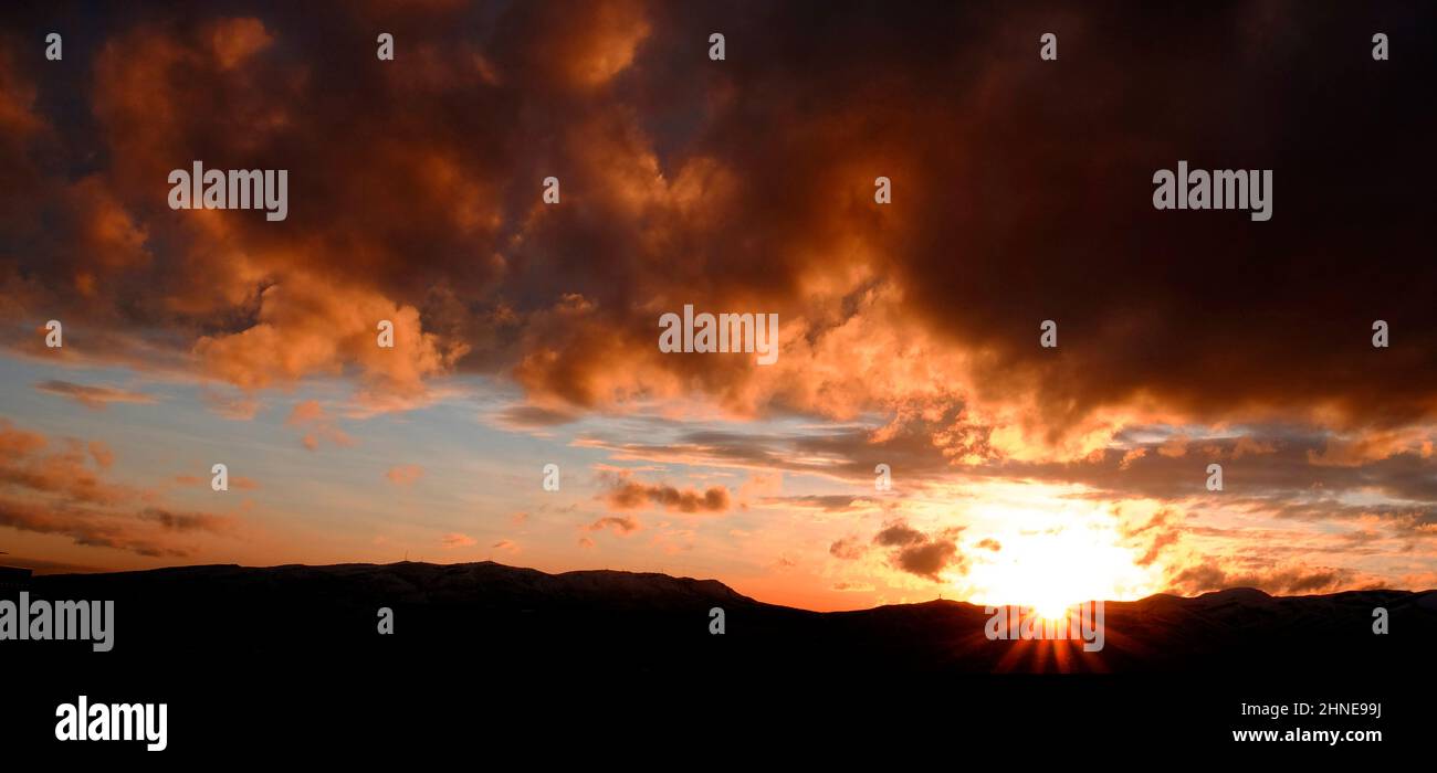 Sonnenuntergang auf Bergen Horizont Wolken sunstar Sonne Stern leuchtet hell im Tal Stockfoto