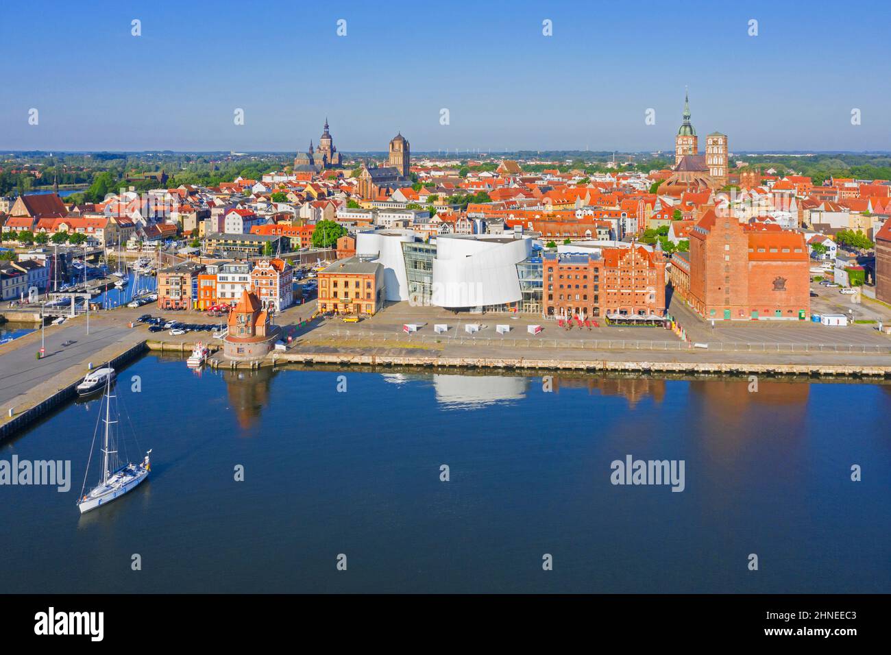 Luftaufnahme über die Uferpromenade und das öffentliche Aquarium Ozeaneum im Hafen der Hansestadt Stralsund im Sommer, Mecklenburg-Vorpommern, Deutschland Stockfoto