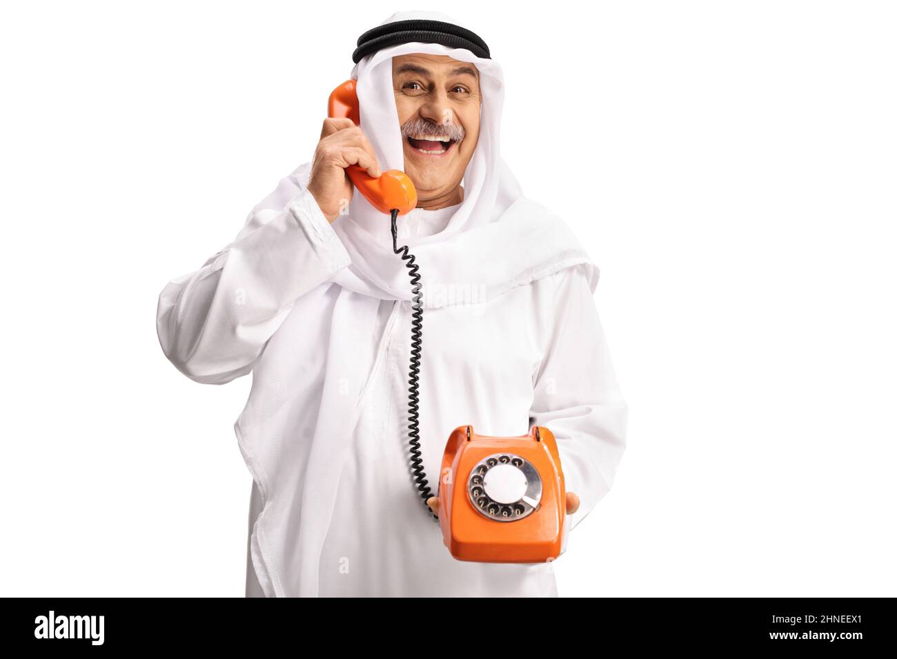 Arabischer Mann mit einem alten Vintage-Drehtelefon und lächelnd isoliert auf weißem Hintergrund Stockfoto