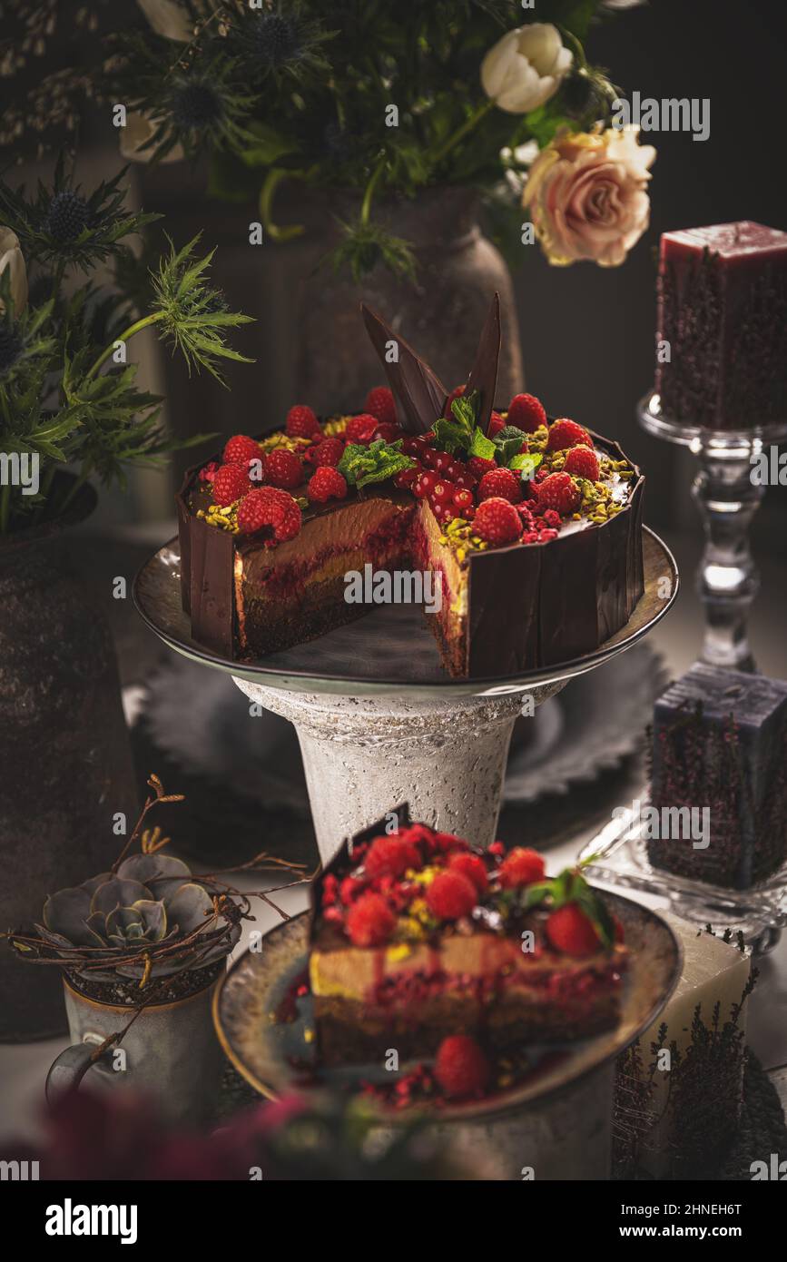 Leckere Mousse-Torte mit geschmolzener Schokolade, verziert mit Himbeeren Stockfoto