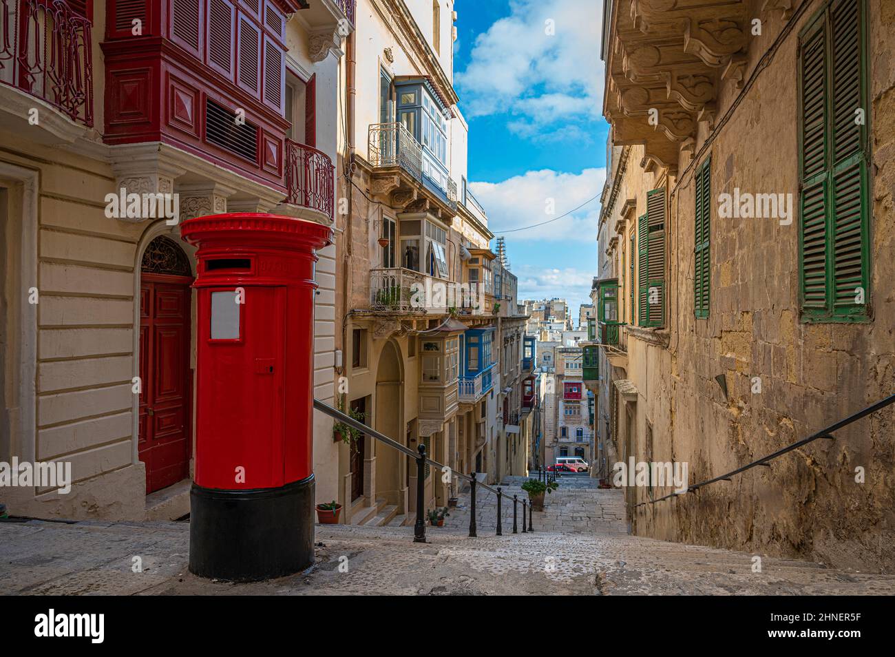 Roter altmodischer Vintage-Briefkasten in einer engen Straße mit Treppen in Valletta, Malta. Stockfoto