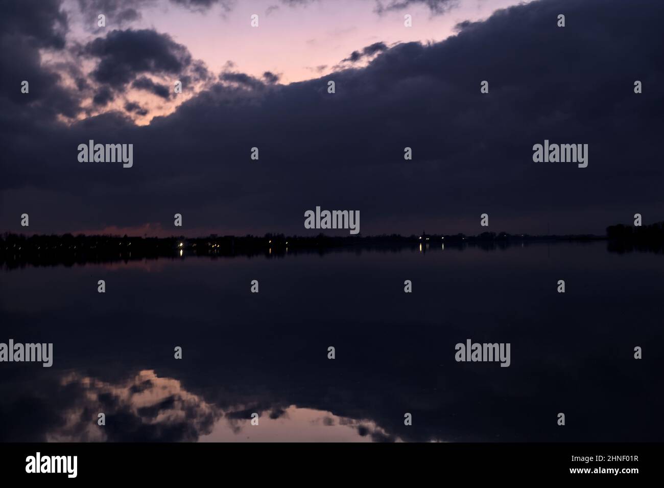 See mit Boys und der Himmel in der Dämmerung auf dem Wasser gegossen Stockfoto