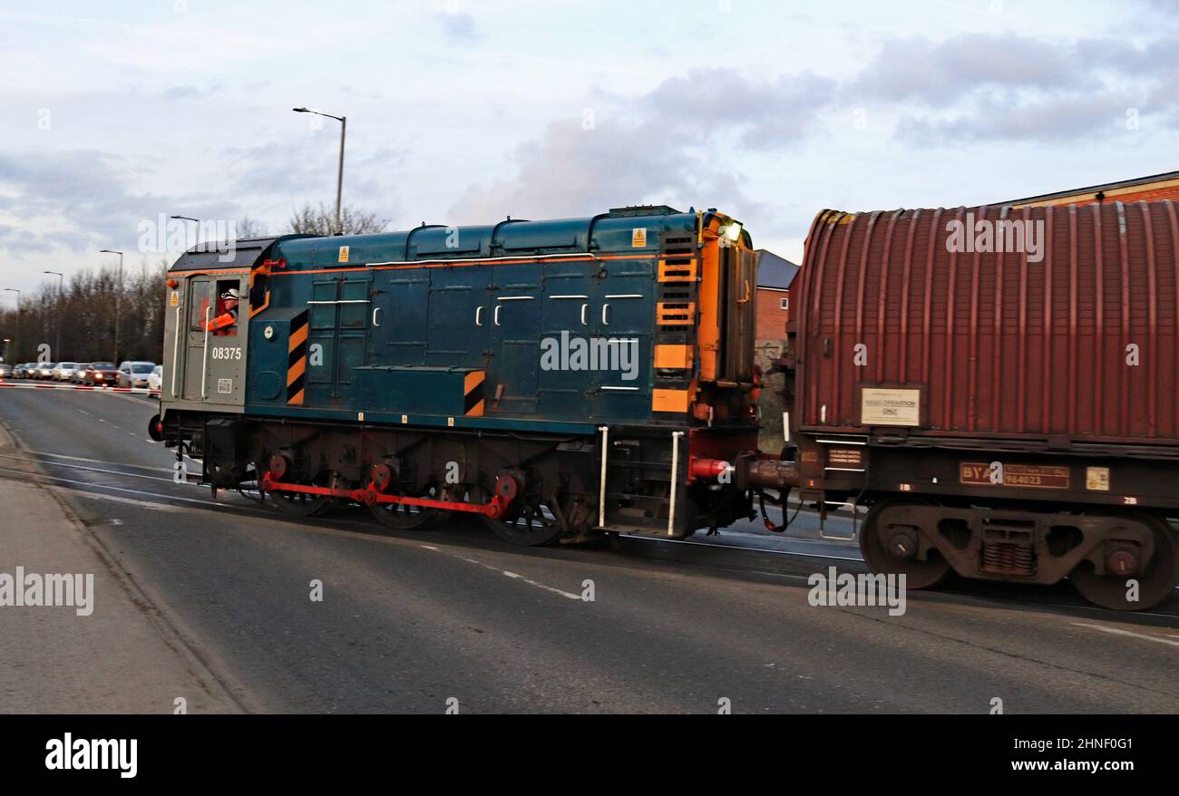 In der Abenddämmerung überquert der Diesel-Rangierwagen Nr. 08 375 die Spalding Road und bringt Stahlwagen zu den Docks in Boston, um dort mit importiertem Stahl beladen zu werden Stockfoto