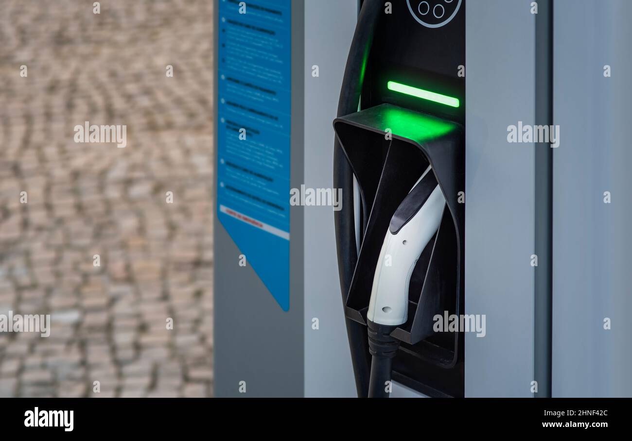 Nahaufnahme des elektrischen Ladesäule-Steckers mit grünem Licht in Lissabon Stockfoto