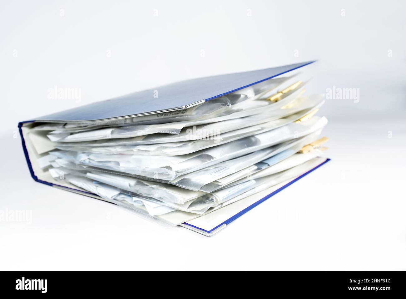 Großer Ringordner mit klaren, gelochten Taschen voller Belege, Büromanagement, Buchhaltungs- und Steuerberechnung, hellgrauem Hintergrund, Kopierraum, s Stockfoto