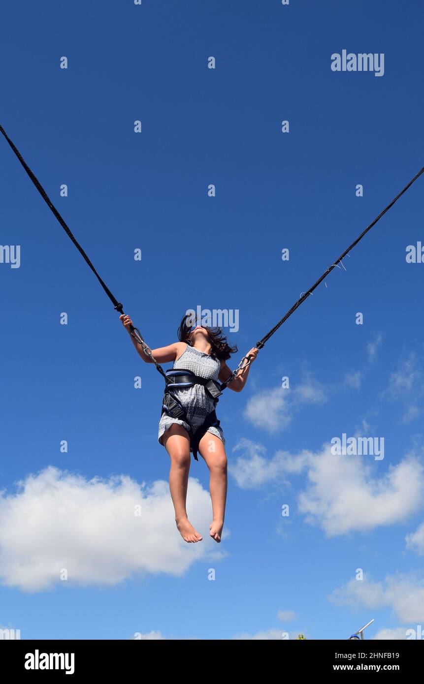 Glückliches Kind, das mit Gummiband in den Himmel springt, glückliche Zeiten. Kinder, die beim Spielen aufwachsen. Stockfoto