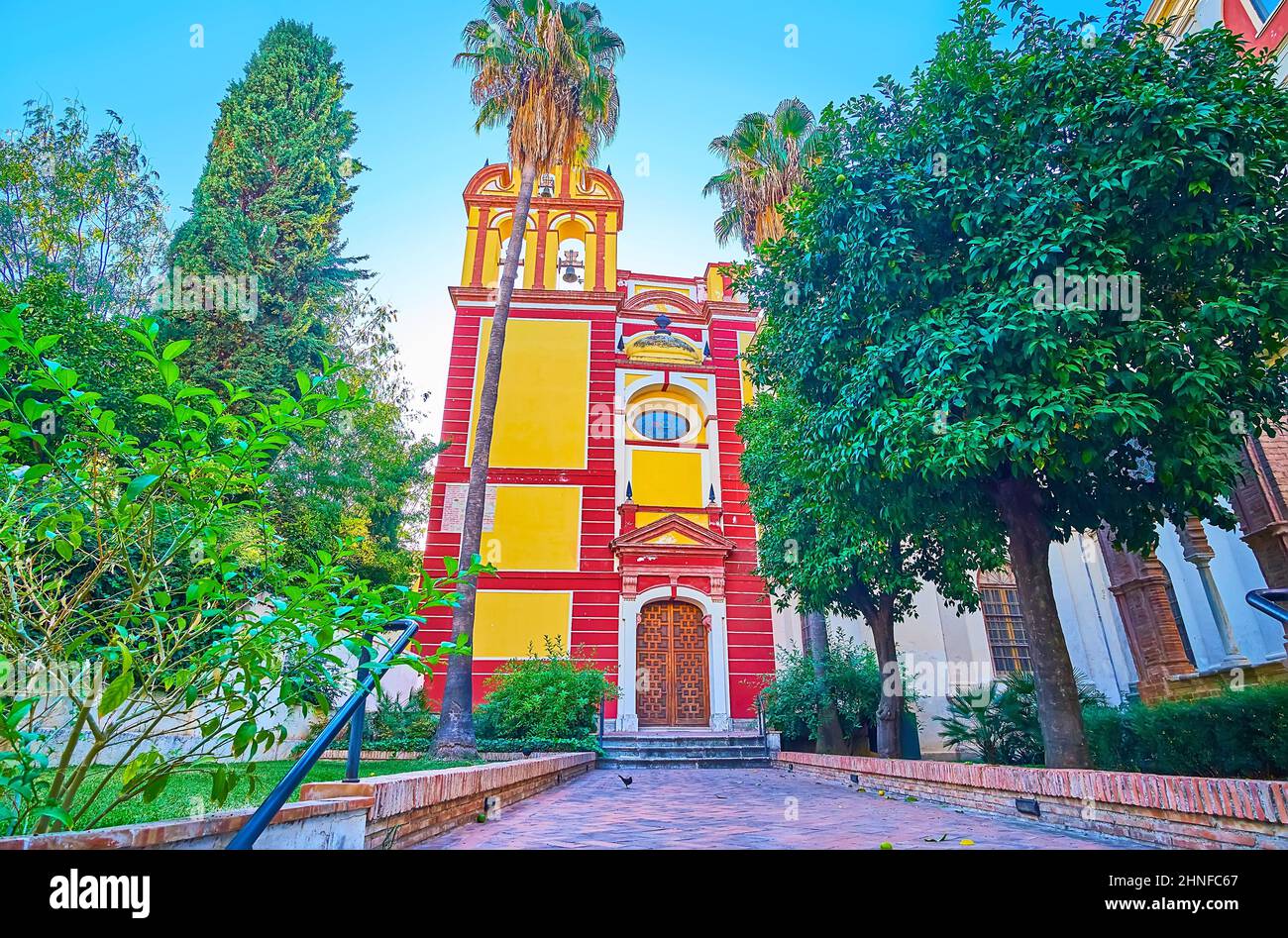 Die rot-gelbe Fassade der historischen Kirche San Agustin, umgeben von einem Garten, die dem Kloster der Agustiner Väter, Malaga, Spanien, gehört Stockfoto