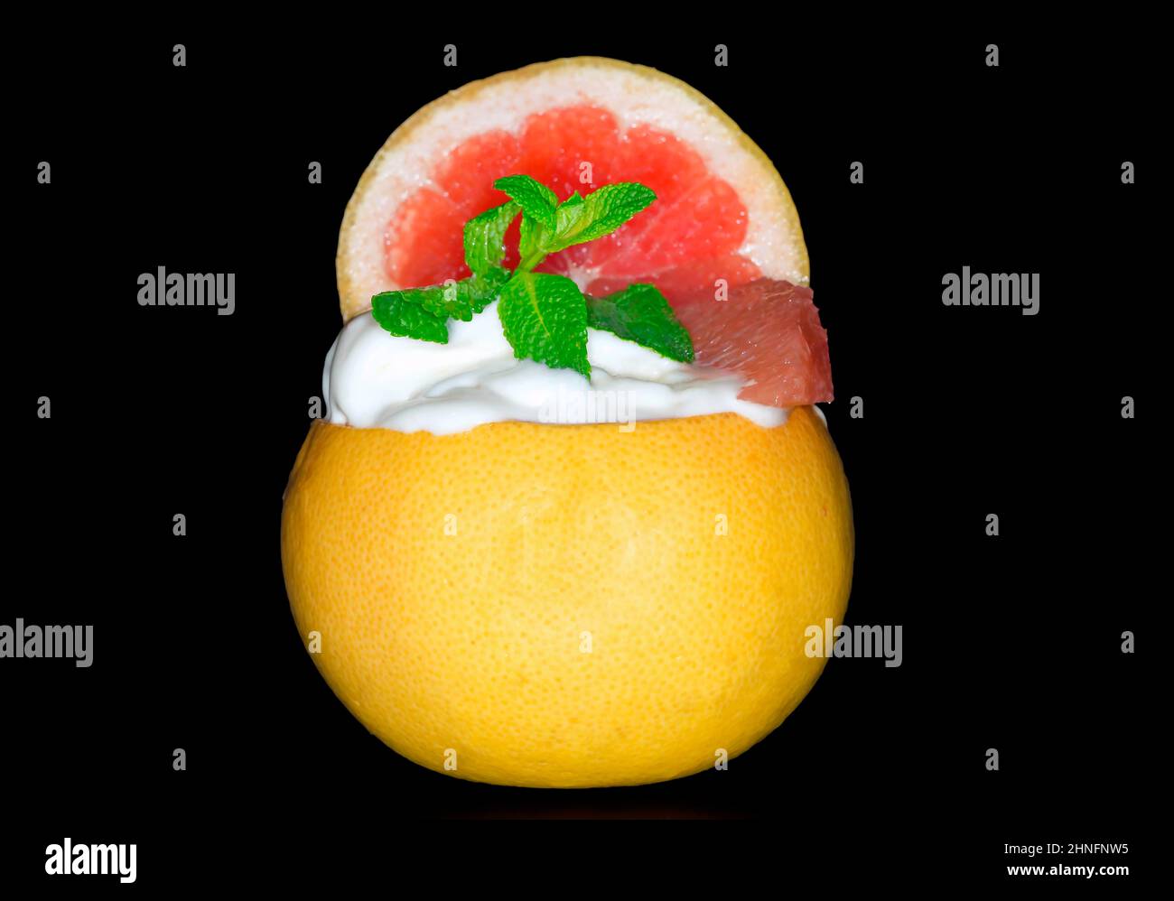 Grapefruitsorbet mit frischer Minze in der Frucht, Studiofotografie mit schwarzem Hintergrund Stockfoto