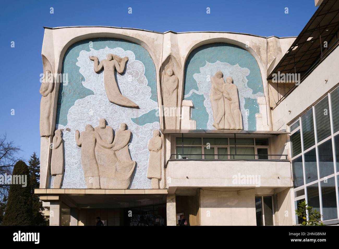 Ein sozialistischer, brutalistischer Betonfriese aus der Sowjetzeit, der im Zentrum für die Entwicklung der medizinischen Arbeiterschule steht. In Taschkent, Usbekistan. Stockfoto