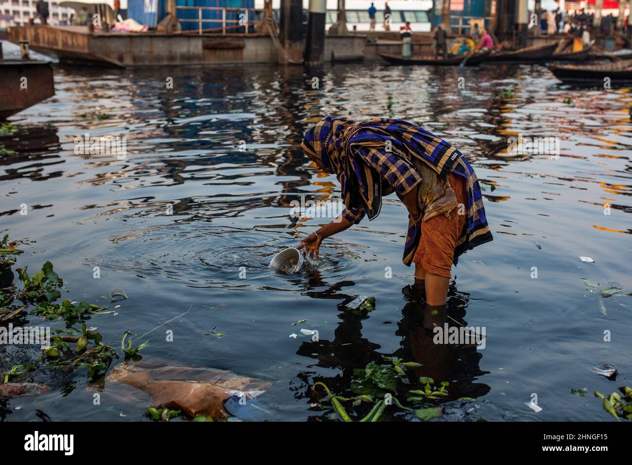 Dhaka, Dhaka, Bangladesch. 17th. Februar 2022. Eine Frau wird gesehen, wie sie Wasser in einem Schiff aus dem stark verschmutzten Buriganga River in Dhaka sammelt. 17. Februar 2022. Dhaka, Bangladesch. (Bild: © Nayem Shaan/ZUMA Press Wire) Stockfoto