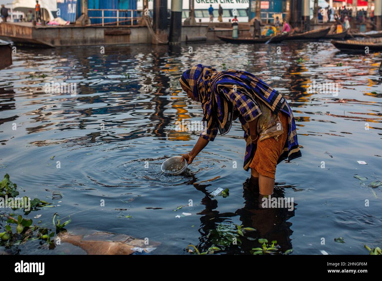 Dhaka, Dhaka, Bangladesch. 17th. Februar 2022. Eine Frau wird gesehen, wie sie Wasser in einem Schiff aus dem stark verschmutzten Buriganga River in Dhaka sammelt. 17. Februar 2022. Dhaka, Bangladesch. (Bild: © Nayem Shaan/ZUMA Press Wire) Stockfoto