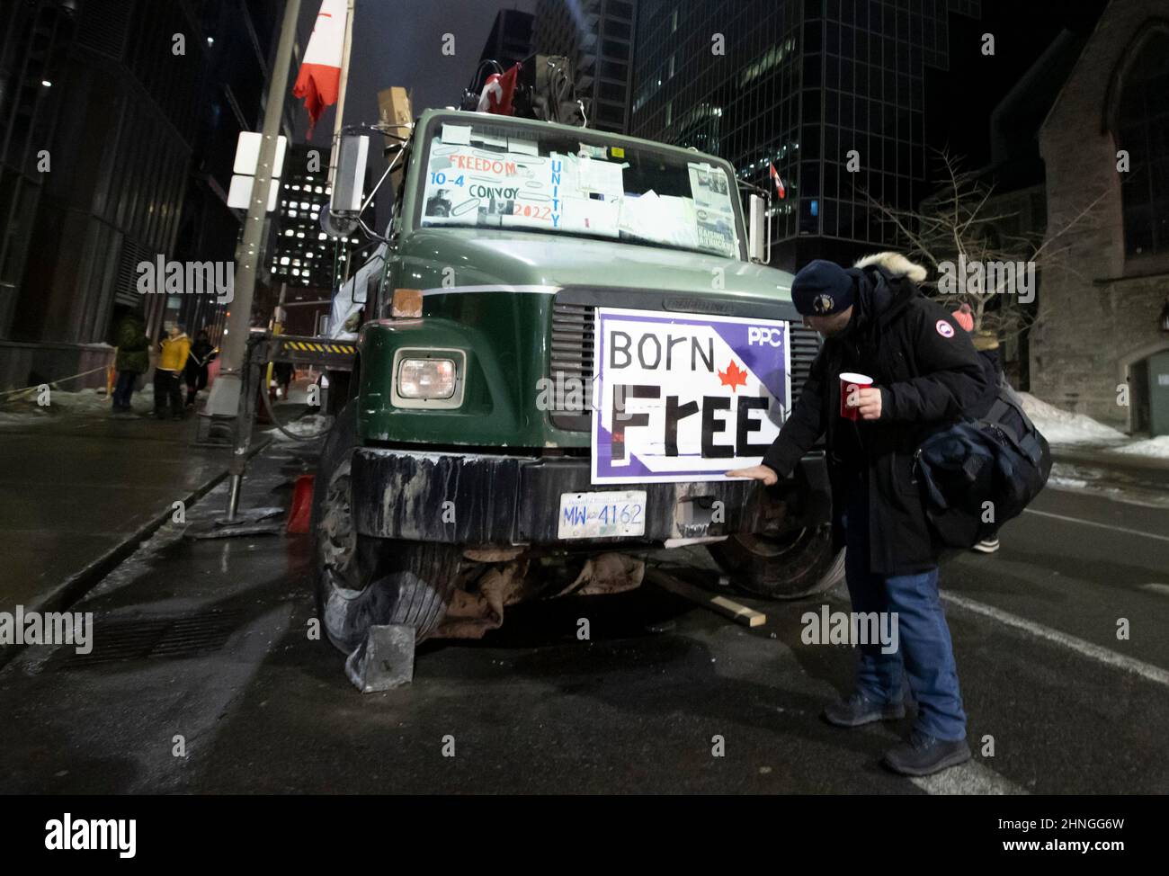 Ottawa, Kanada. 16. Februar 2022. Ein Protestierender posiert mit einem Lastwagen am Abend des 20th. Tages der Besetzung der Innenstadt von Ottawa durch Demonstranten. Kredit: Sean Burges / Stockfoto