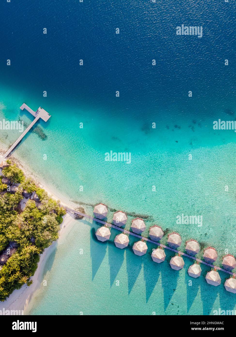 Überwasser-Villen und weißer Sandstrand auf einer tropischen Insel für Urlaubsreisen und Flitterwochen. Luxus-Resort-Hotel auf den Malediven oder der Karibik mit Stockfoto