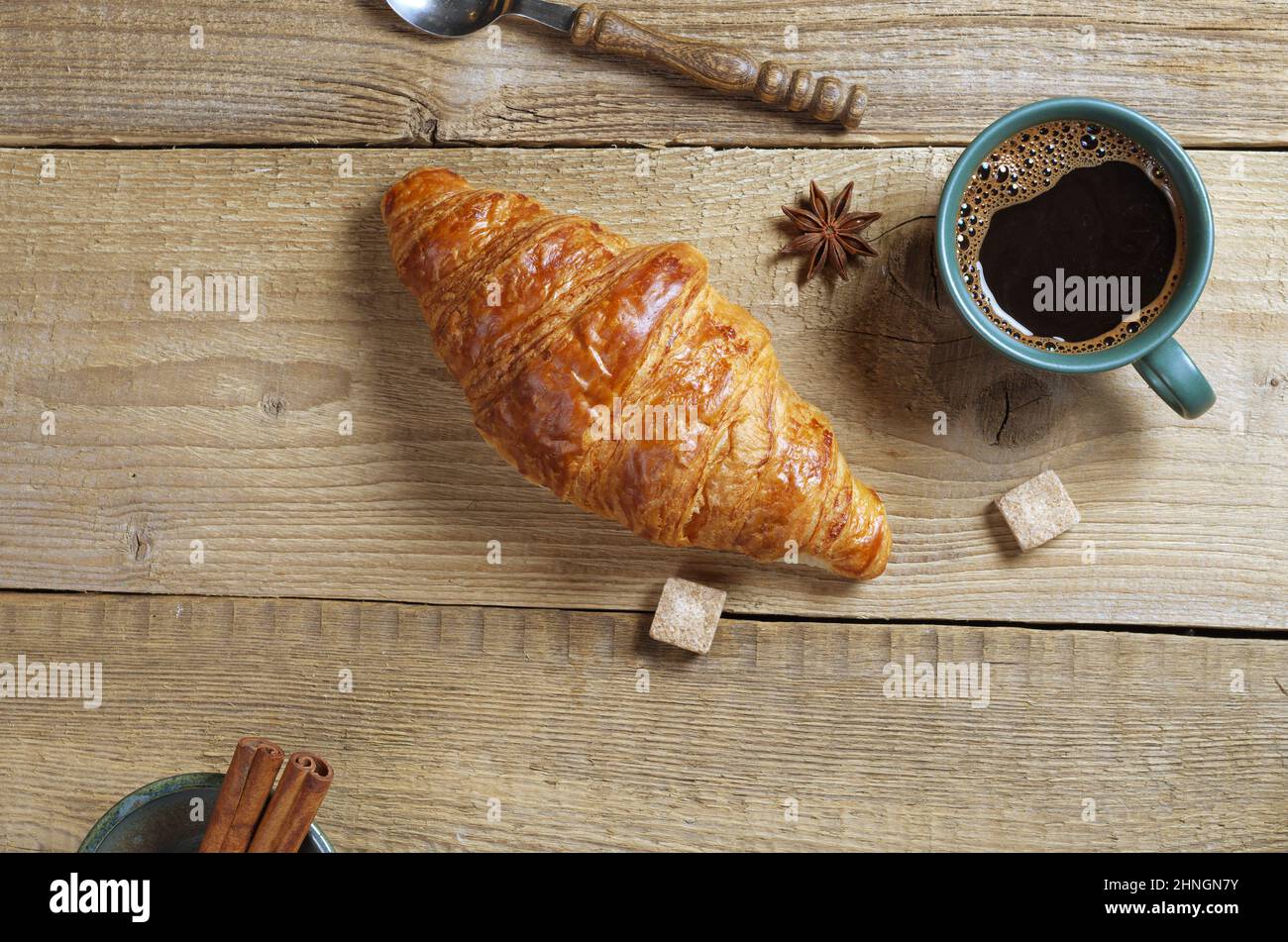 Tasse Kaffee und Croissant auf altem Holzhintergrund, Draufsicht mit Kopierplatz. Thema Frühstück oder Pause Stockfoto