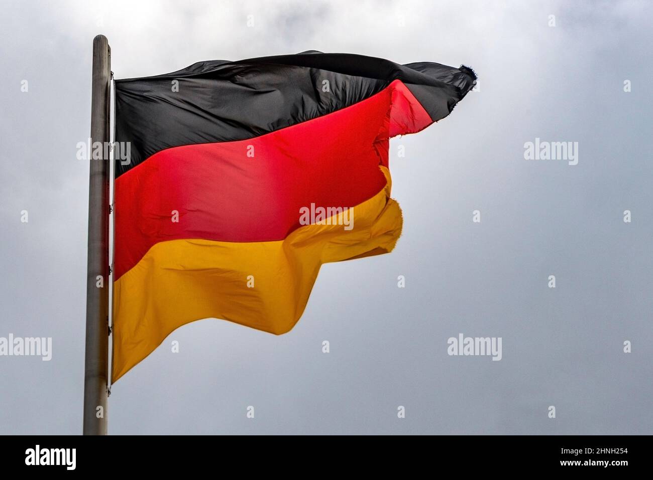 Im berühmten Reichstagsgebäude, dem Sitz des Deutschen Bundestages, winken deutsche Flaggen im Wind an einem sonnigen Tag mit blauem sk Stockfoto