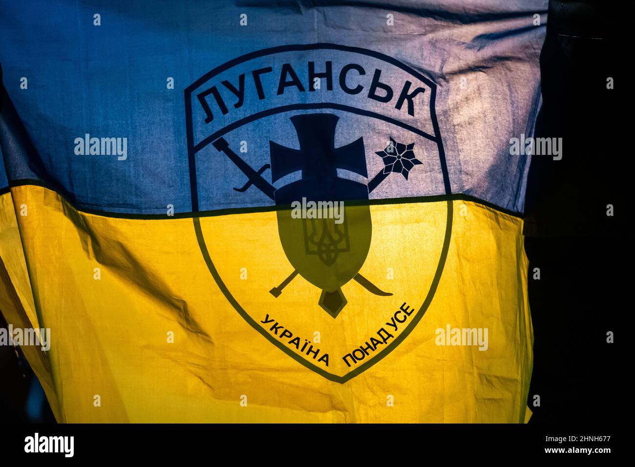 Flagge der Ukraine vor allem mit Symbol- oder Logo-Silhouette der Stadt Luhansk oder Lugansk nahe der Grenze zu Russland in der umstrittenen Region Donbass Stockfoto
