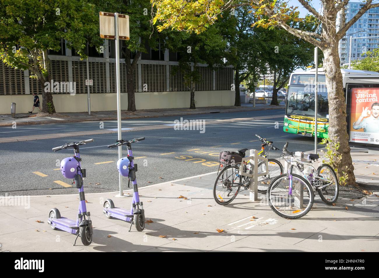Canberra Bus im Stadtzentrum, geparkte Fahrräder und gemeinsame elektronische E-Scooter in der Nähe, ACT, Australien Stockfoto
