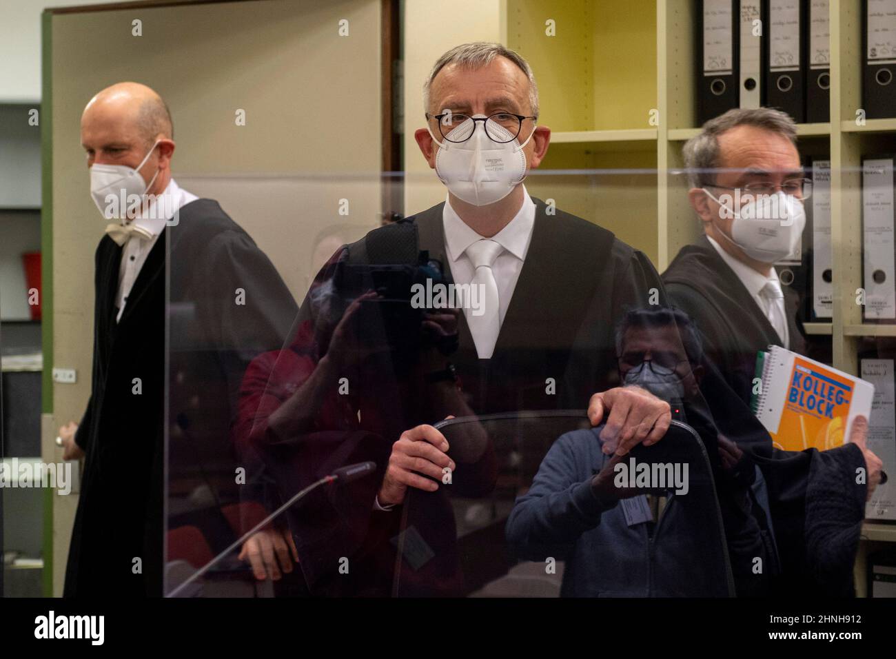 München, Deutschland. 17th. Februar 2022. Der Vorsitzende Richter am Oberlandesgericht Jochen Bösl (Mitte) und seine Mitrichter kommen zum Beginn des Prozesses gegen den mutmaßlichen russischen Raketenspion in den Gerichtssaal des Oberlandesgerichts. Der beschuldigte Wissenschaftler war an der Universität Augsburg tätig und soll seit Ende 2019 Informationen über Forschungsprojekte im Bereich der Luft- und Raumfahrttechnik an den russischen Geheimdienst SWR, insbesondere aus den verschiedenen Entwicklungsstufen der europäischen Trägerrakete Ariane, weitergegeben haben. Kredit: Lennart Preiss/dpa/Alamy Live Nachrichten Stockfoto