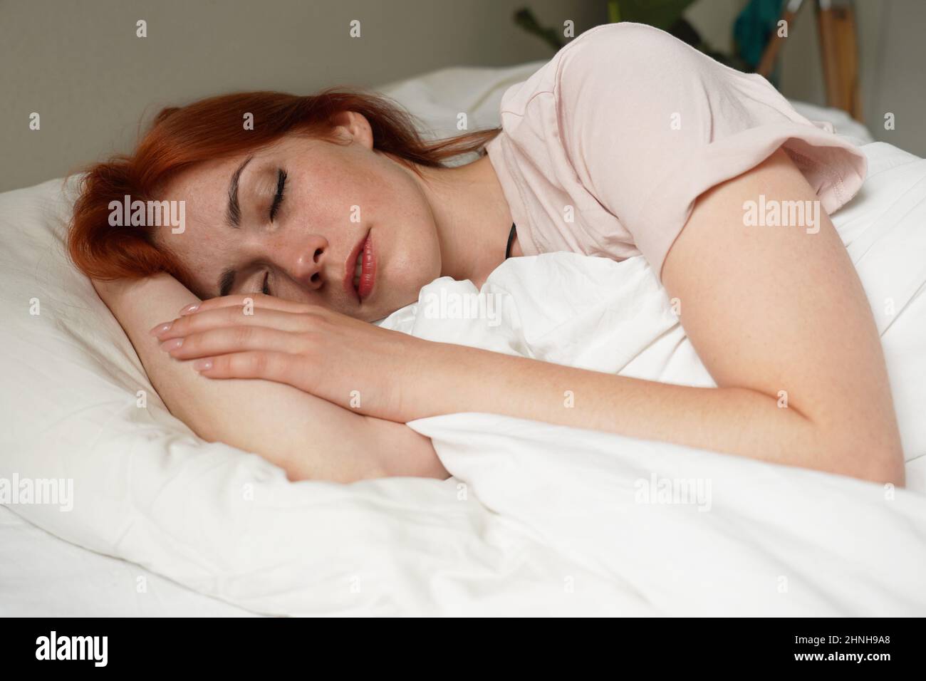 Junge Frau im Bett, die tagsüber schläft oder schlaft Stockfoto