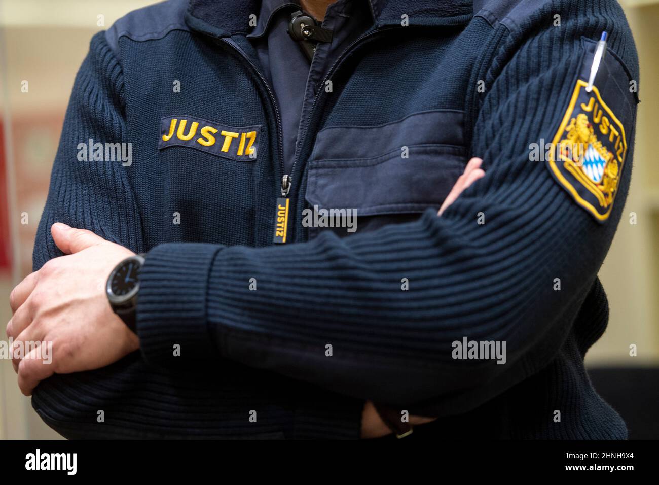 München, Deutschland. 17th. Februar 2022. Ein Angestellter der Justiz steht im Gerichtssaal des Oberlandesgerichts für den Beginn des Prozesses gegen den angeblichen russischen Raketenspion. Der beschuldigte Wissenschaftler war an der Universität Augsburg tätig und soll seit Ende 2019 Informationen über Forschungsprojekte im Bereich der Luft- und Raumfahrttechnik an den russischen Geheimdienst SWR, insbesondere aus den verschiedenen Entwicklungsstufen der europäischen Trägerrakete Ariane, weitergegeben haben. Kredit: Lennart Preiss/dpa/Alamy Live Nachrichten Stockfoto