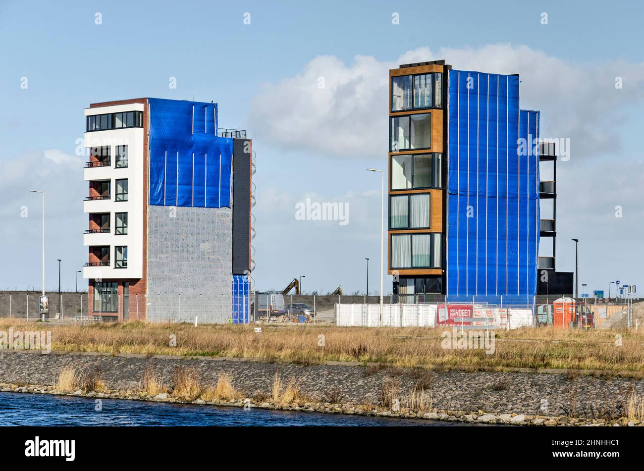 Amsterdam, Niederlande, 11. Februar 2022: Zwei Wohngebäude im Stadtteil IJburg, fast fertig gestellt, während der Bau für den Nachbarn Stockfoto