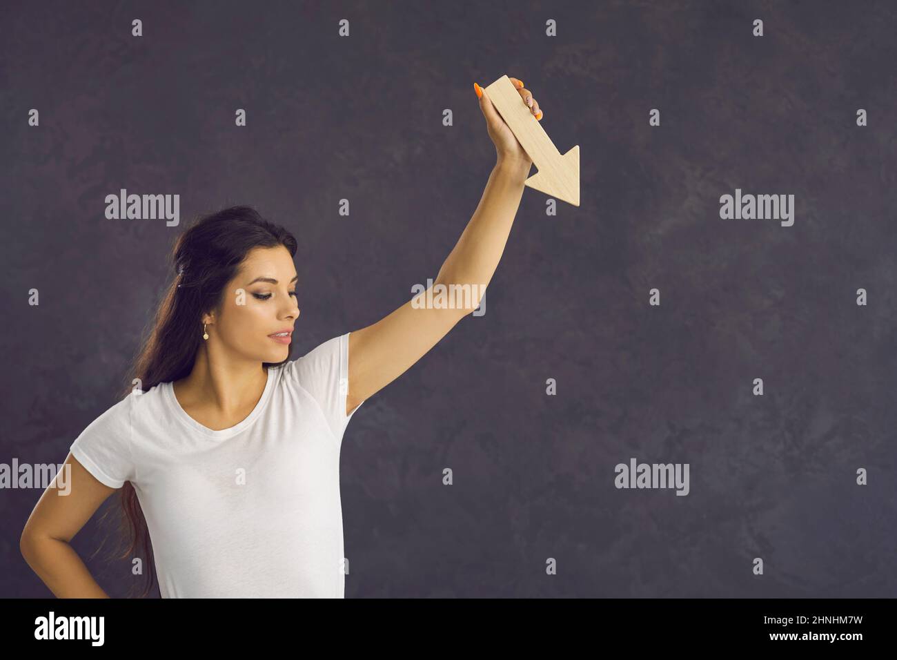 Die Geschäftsfrau hält den Pfeil nach unten und zeigt einen Rückgang der Finanzen Stockfoto