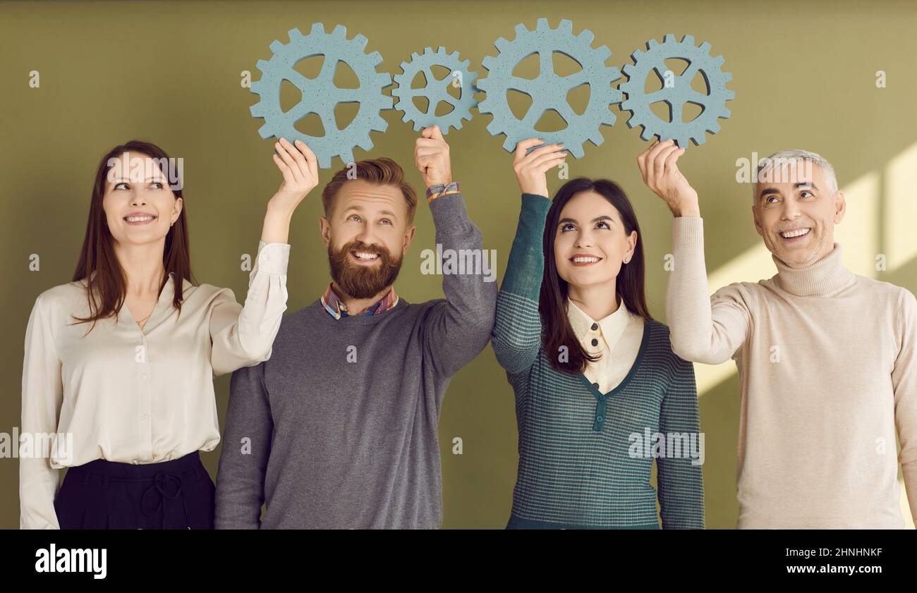 Team von Geschäftsleuten, die Zahnräder verbinden, um das Konzept der effektiven Teamarbeit zu zeigen Stockfoto