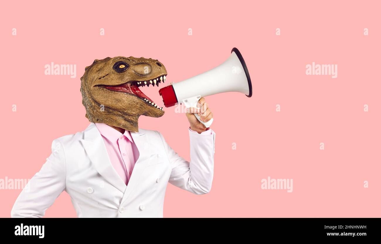 Lustiger Mann mit Dinosauriermaske, der Ankündigung macht und durch das Megaphon brüllt Stockfoto