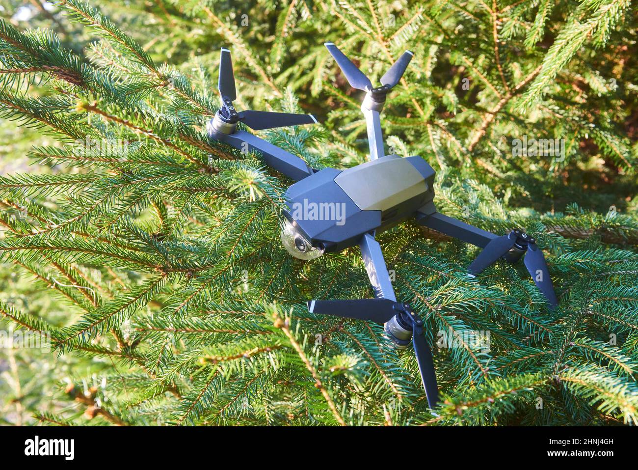 Zerbrochene zerstörte Drohne nach einem Unfall, der in den Ästen eines Baumes hing Stockfoto