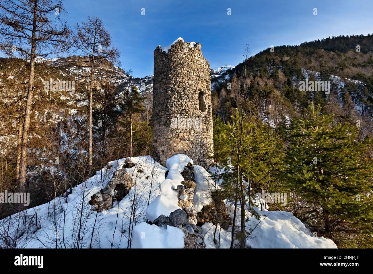 Der zylindrische Turm der Burg San Pietro erhebt sich an einem abgelegenen und wilden Ort des Rinassico-Tals. Ton, Trentino, Italien. Stockfoto