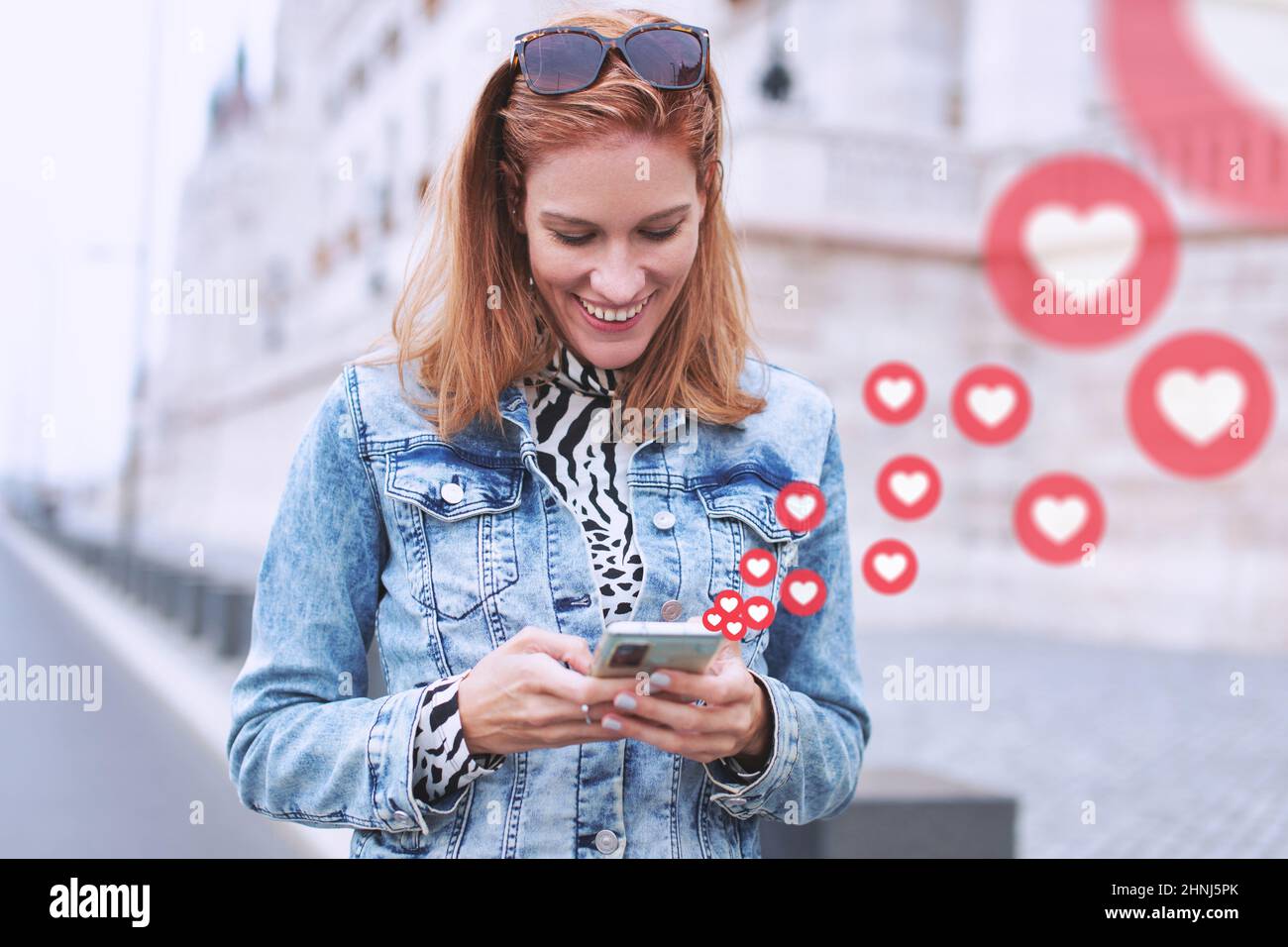 Glückliche junge Stadtfrau Social Media Messaging mit Liebesreaktionen Stockfoto