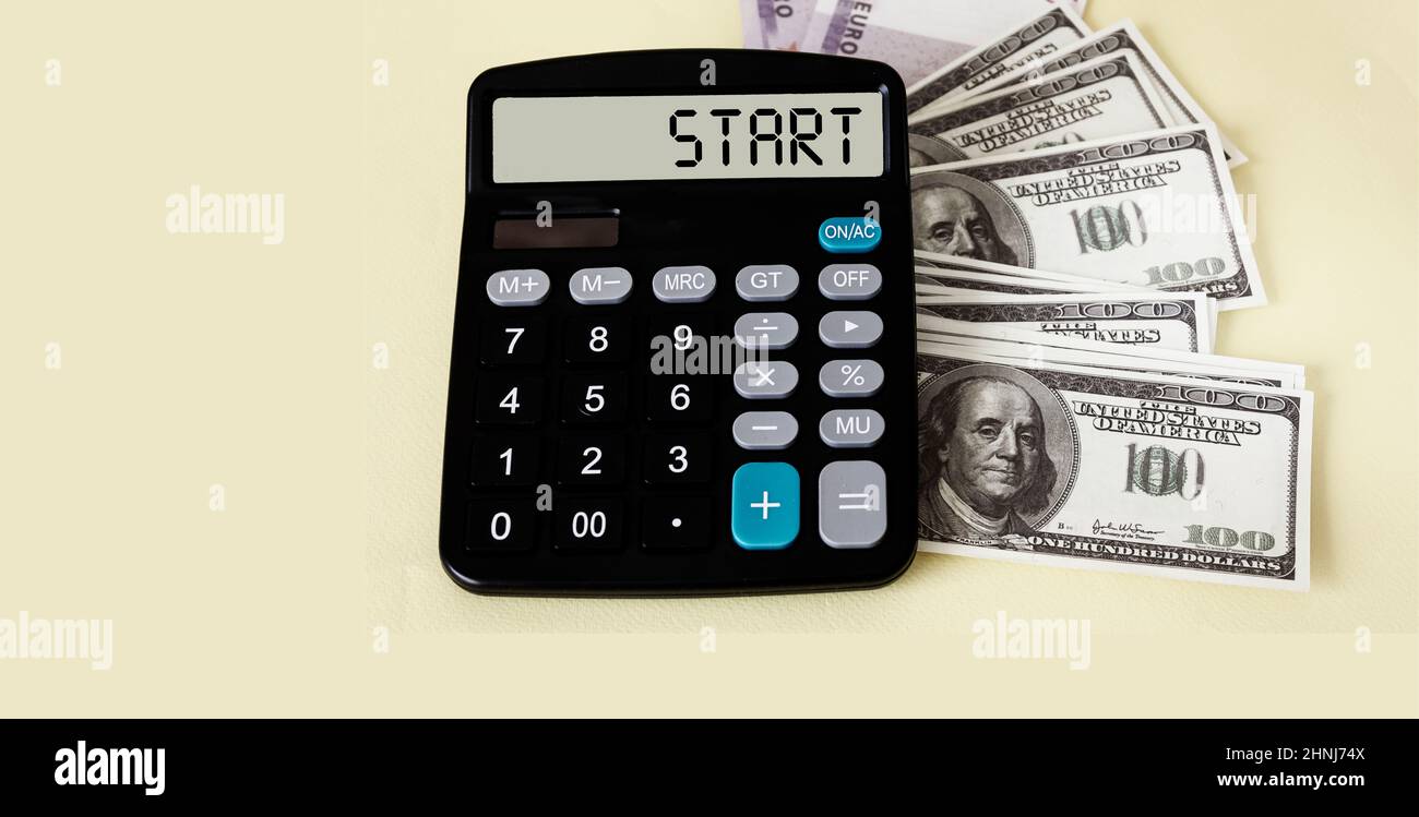 Starttext auf der Taschenrechner-Anzeige mit Dollarnoten auf weißem Hintergrund Stockfoto
