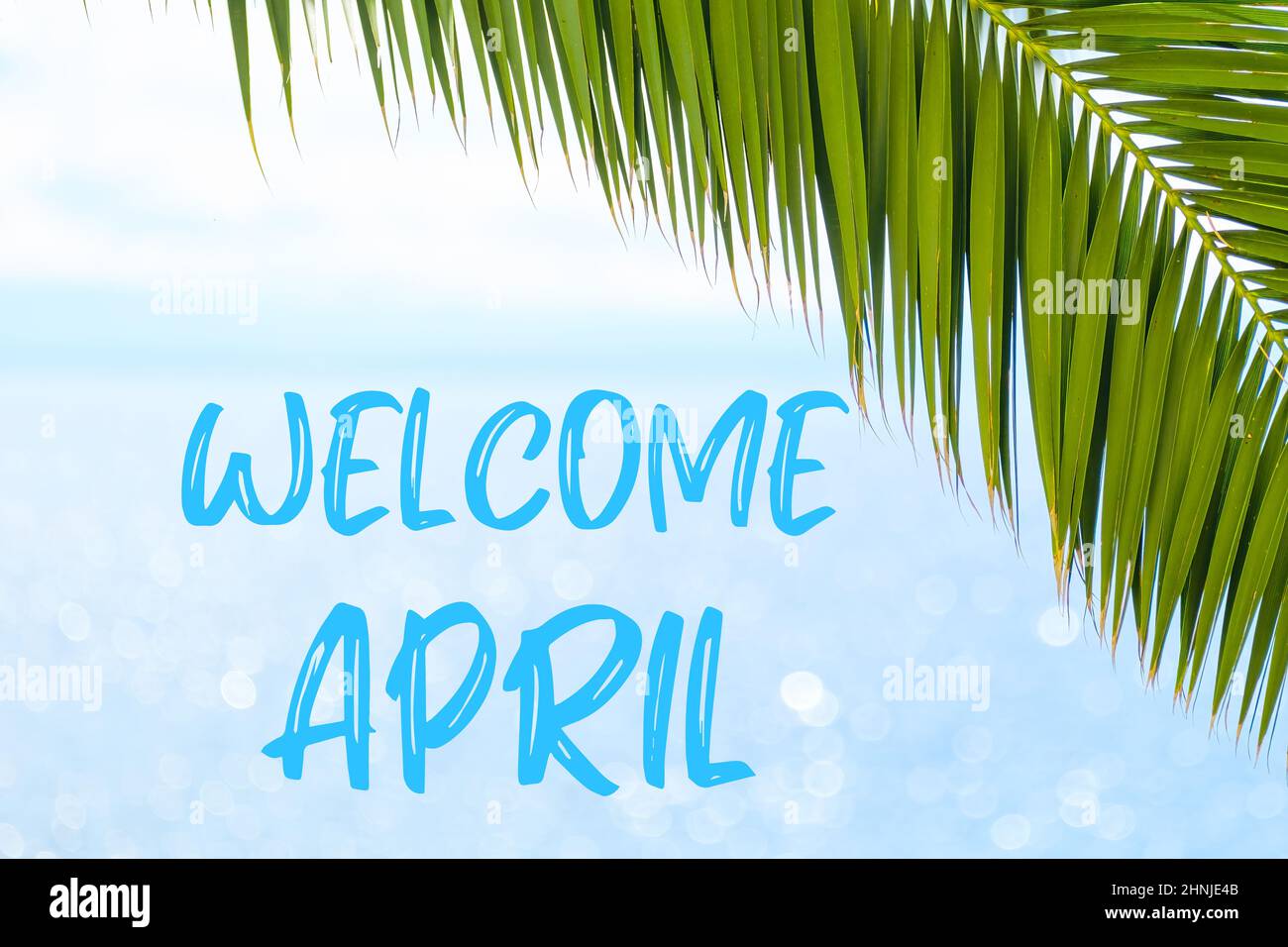 Begrüßung April Nachricht in eleganter Schrift auf dem Hintergrund mit Palmblatt und blauem Meer geschrieben. Urlaubskonzept und Werbung der Reiseagentur. Stockfoto