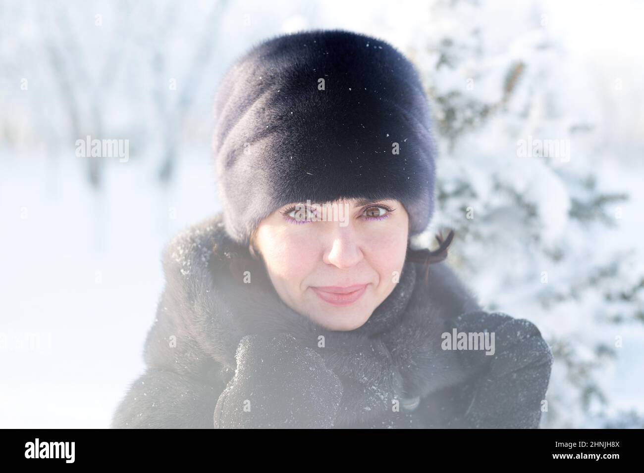 Porträt einer 40-jährigen Frau in Winterkleidung vor Schnee. Stockfoto