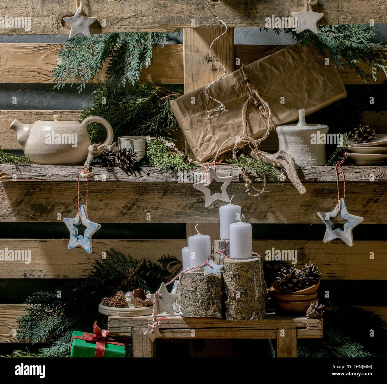 Weihnachtliche Mode rustikaler Stil Wohneinrichtung mit handwerklichem Holz, Keramik und Geschenkschachteln mit Adventskerzen auf alten Holzpaletten-Regalen als Backgr Stockfoto