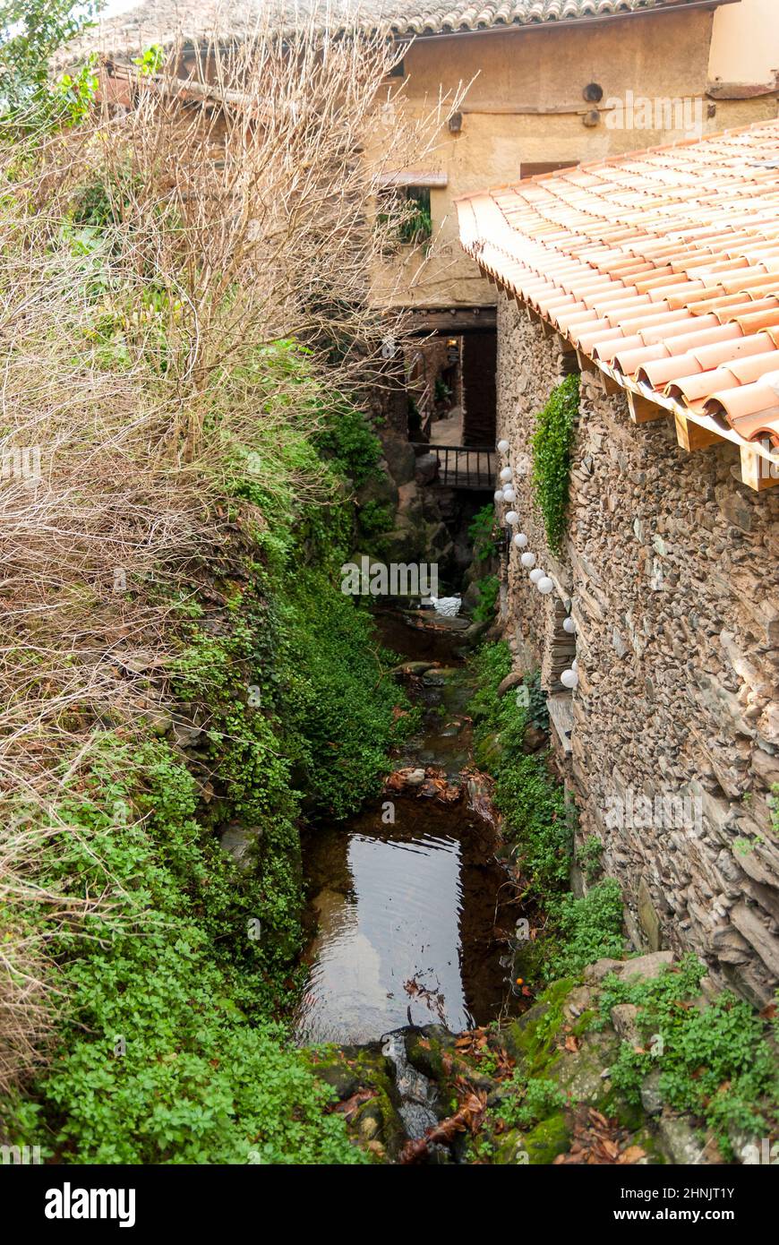 Typische Ecke mit einem kleinen Bach, der durch die Straßen von Robledillo de Gata fließt Stockfoto