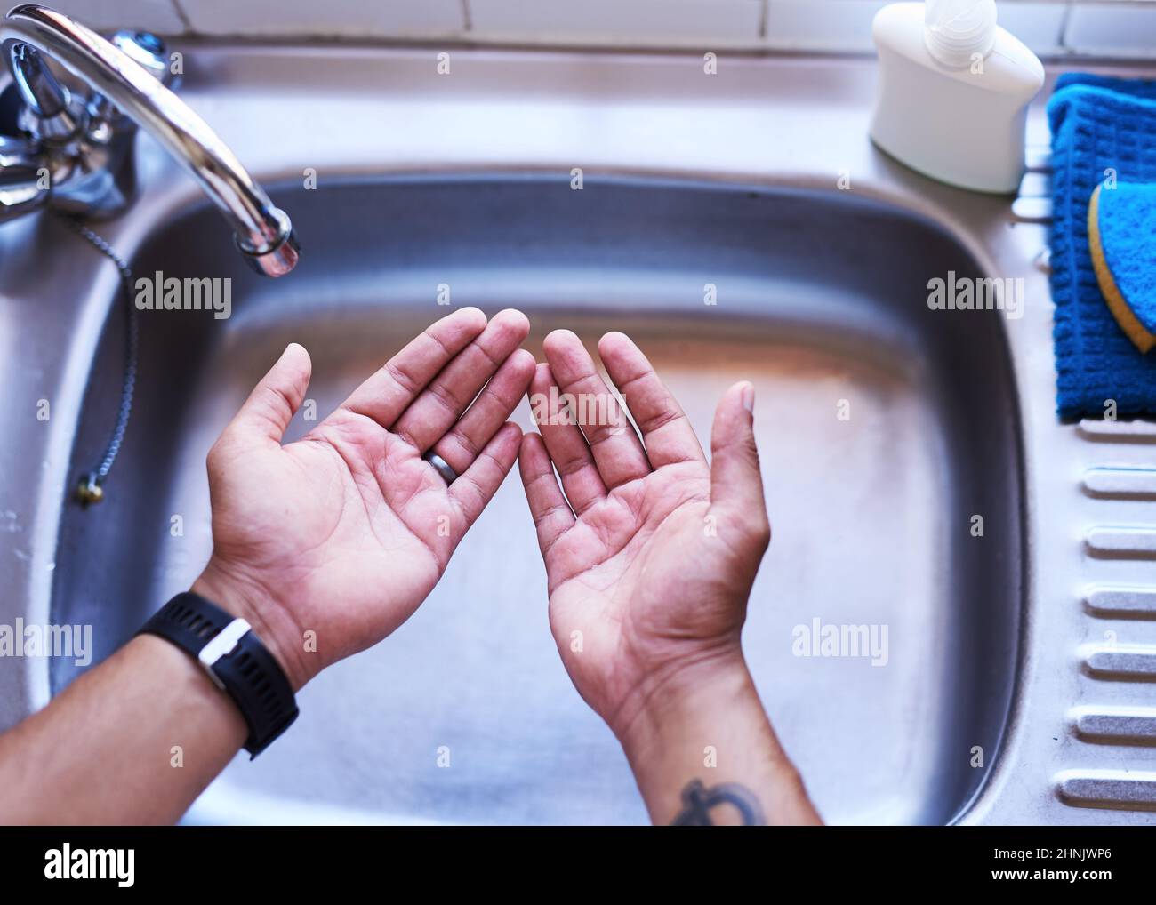 Ein erwachsener Mann, der sich vorbereitete, sich die Hände zu waschen, wurde über den Kopf geschossen Stockfoto