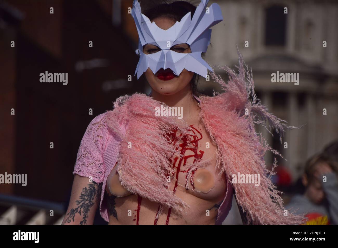 London, Großbritannien. 17th. Februar 2022. PETA-Aktivisten mit Vogelmasken und freigelegten „blutigen und gerupften“ Truhen inszenierten auf der Millennium Bridge einen „Laufsteg“, um gegen den Einsatz von Vogelfedern in Kleidungsstücken und Accessoires auf der London Fashion Week zu protestieren. Kredit: Vuk Valcic/Alamy Live Nachrichten Stockfoto