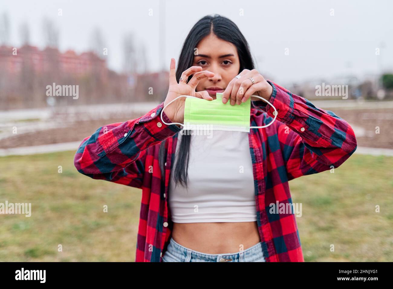 latina Frau bricht eine Anti-Covid-Maske 19. Konzept des Pandemie-Endes Stockfoto