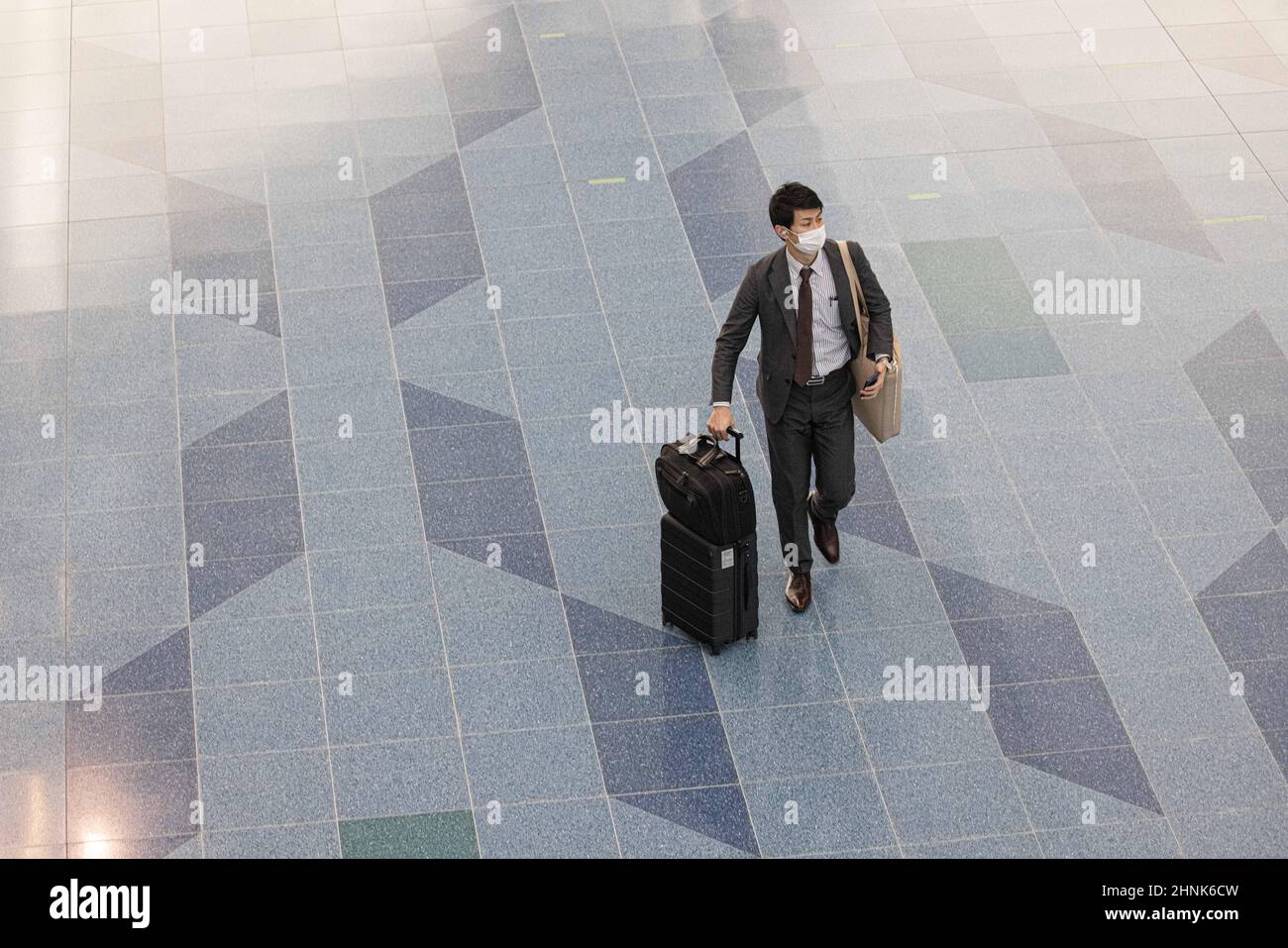 Tokio, Japan. 17th. Februar 2022. Ein Passagier mit Gesichtsmaske geht mit seinem Gepäck durch den Abflugbereich des Flughafens Haneda.Japans Premierminister Fumio Kishida kündigte auf seiner Pressekonferenz am 17th 2022. Februar an, dass Japan die Einreisebeschränkungen für ausländische Studenten und Geschäftsreisende lockern und die Quarantänezeit für verkürzen wird Alle Ankünfte zu drei Tagen. (Foto: Stanislav Kogiku/SOPA Images/Sipa USA) Quelle: SIPA USA/Alamy Live News Stockfoto