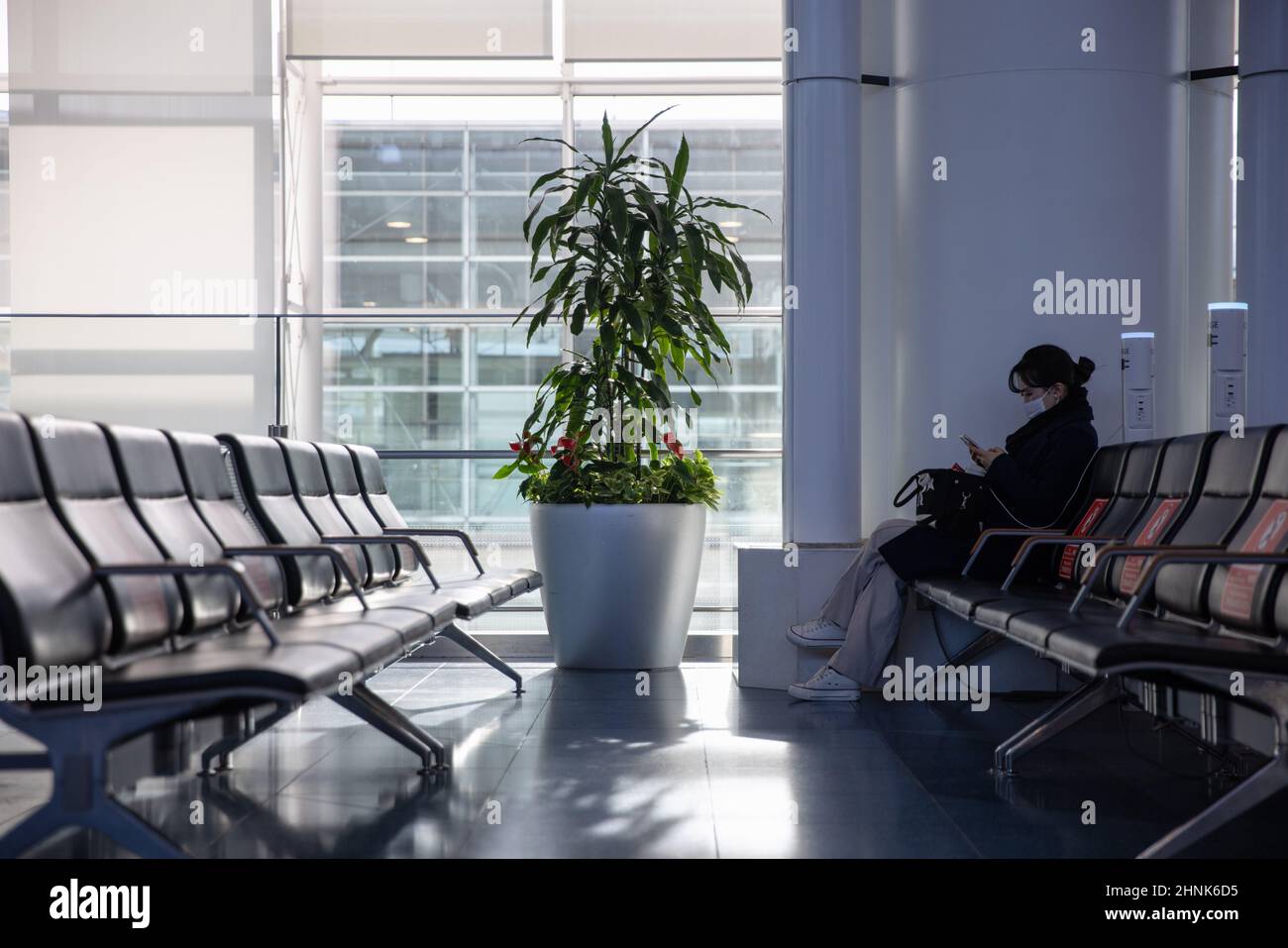 Tokio, Japan. 17th. Februar 2022. Eine Fluggast mit Gesichtsmaske lädt ihr Telefon im Abflugbereich des Flughafens Haneda auf.Japans Premierminister Fumio Kishida kündigte auf seiner Pressekonferenz am 17th 2022. Februar an, dass Japan die Einreisebeschränkungen für ausländische Studenten und Geschäftsreisende lockern und die Quarantänezeit für alle verkürzen werde Ankunft bis drei Tage. (Foto: Stanislav Kogiku/SOPA Images/Sipa USA) Quelle: SIPA USA/Alamy Live News Stockfoto